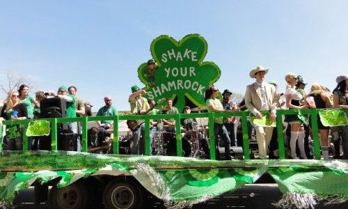 People in the parade in green vehicle in Dallas.