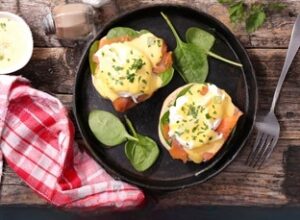 Elegant Eggs Benedict with salmon served at Sadelle's, garnished with fresh herbs. Savory breakfast tacos at a must-visit brunch spot in Dallas