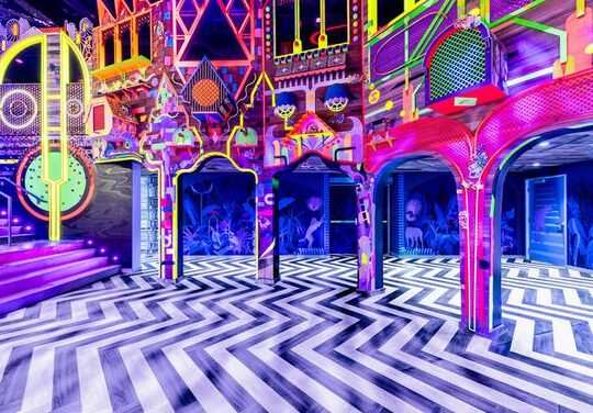 Immersive, surreal interior scene at The Real Unreal by Meow Wolf in Dallas, Texas, featuring vibrant colors, abstract installations, and interactive art pieces.