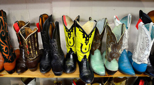 A display of vibrant, colorful cowgirl boots showcasing various designs and patterns, highlighting the traditional western style.