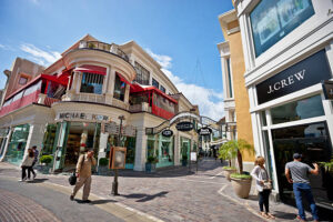 Los Angeles, USA - May 7, 2013: The Grove Shopping Mall - Los Angeles. Michael Kors store, people walking on the mall street. Man and woman looking at window display of J.Crew store.