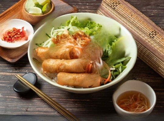 A delicious spread featuring fresh spring rolls and vibrant vermicelli bowls from a Dallas food truck, highlighting colorful vegetables, herbs, and proteins like shrimp or grilled chicken.