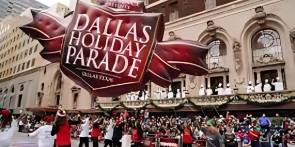 people holding Dallas Holiday Parade banner on the road.