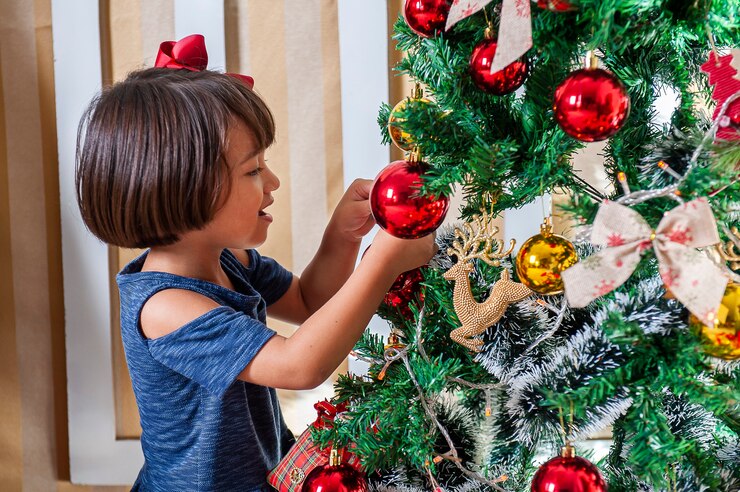 Child decorating Christmas tree a Thanksgiving and Christmas traditions 